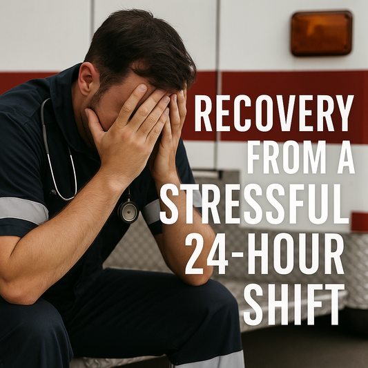 A tired paramedic sits on the back bumper of an ambulance, head in hands, wearing a navy uniform with reflective stripes.