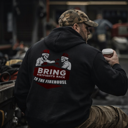 Back view of a firefighter wearing the black "Firehouse Fistfights" hoodie holding a coffee cup — "Bring Fistfights Back to the Firehouse" skeleton boxer graphic — lifestyle shot in a firehouse bay.