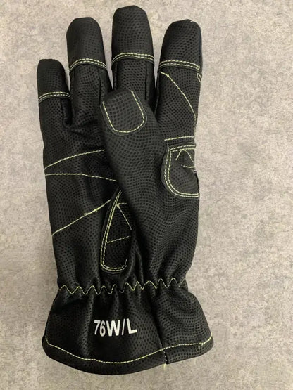 Black glove with green stitching on a gray background