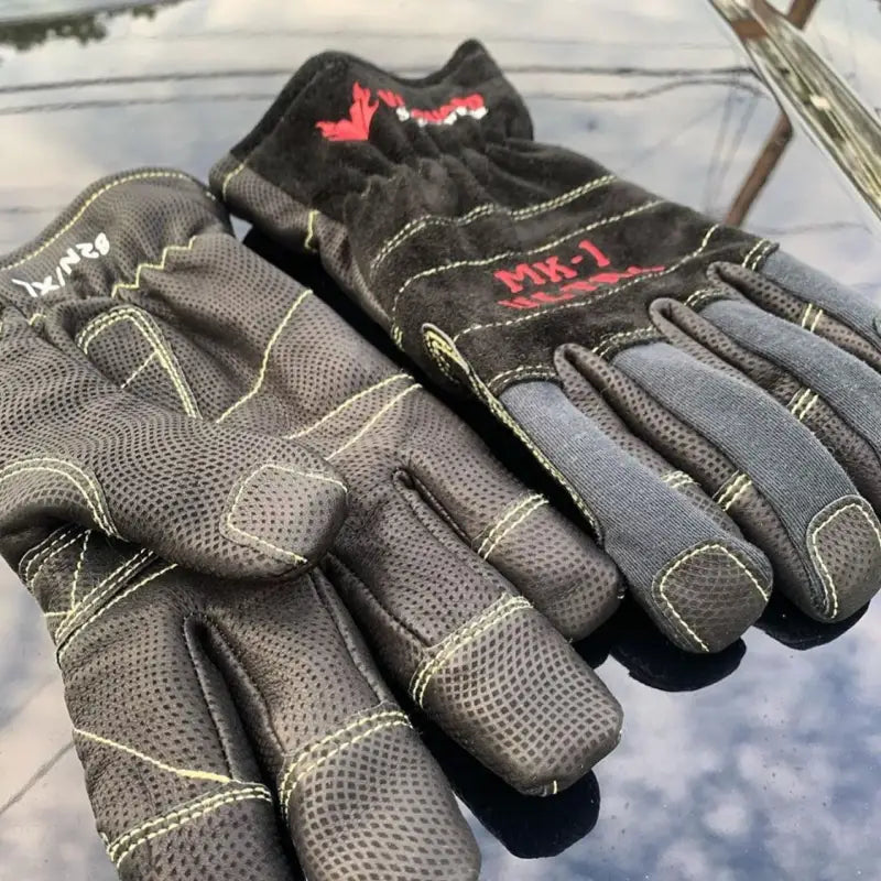 Pair of black and gray gloves with brand logos on a reflective surface
